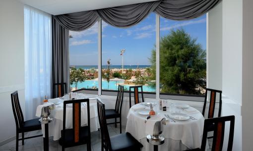 Elegantes Restaurant mit Meer- und Poolblick, raffinierte Einrichtung.