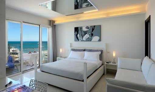 Modern room with sea view, double bed, and balcony.
